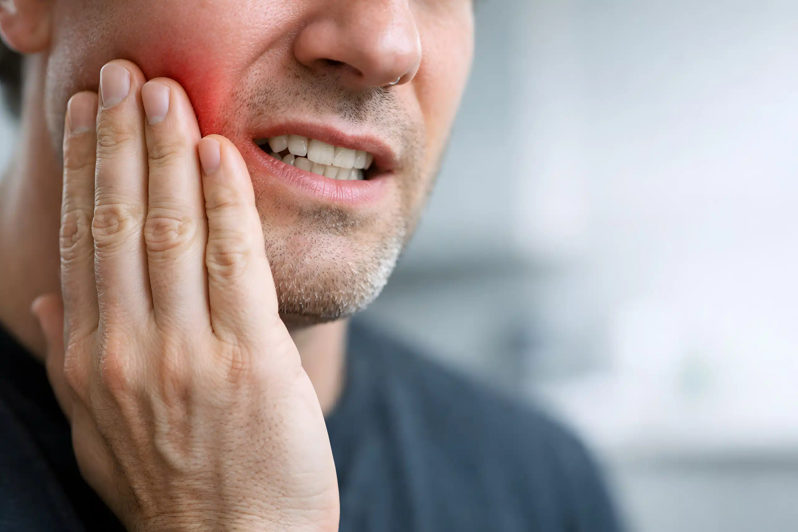 Man Holding Jaw in Severe Pain